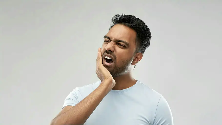 Man holding his jaw with tooth pain